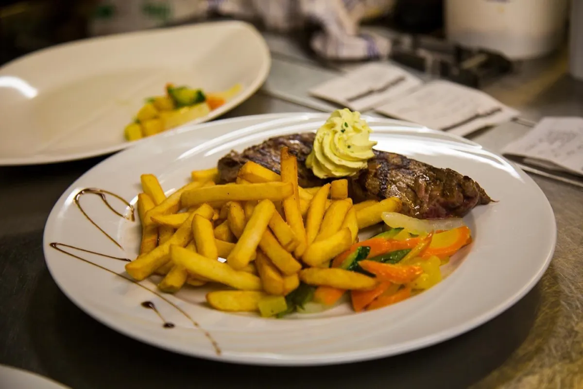 Entrecôte grillée au beurre aux herbes, frites et légumes